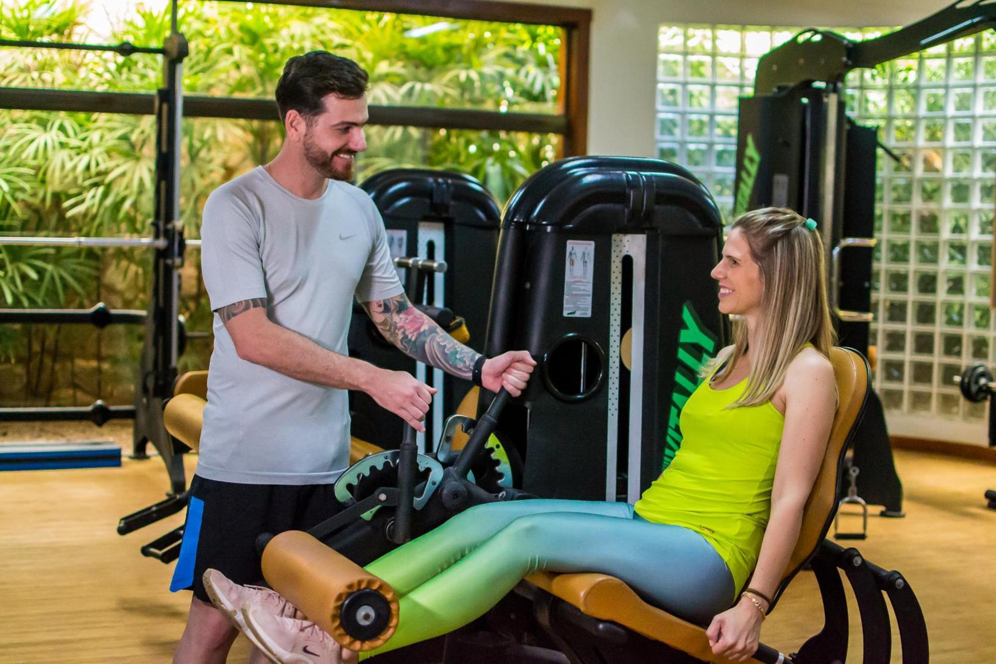 Blue Tree Thermas De Lins Resort المظهر الخارجي الصورة Personal trainer assisting a woman on a leg press machine